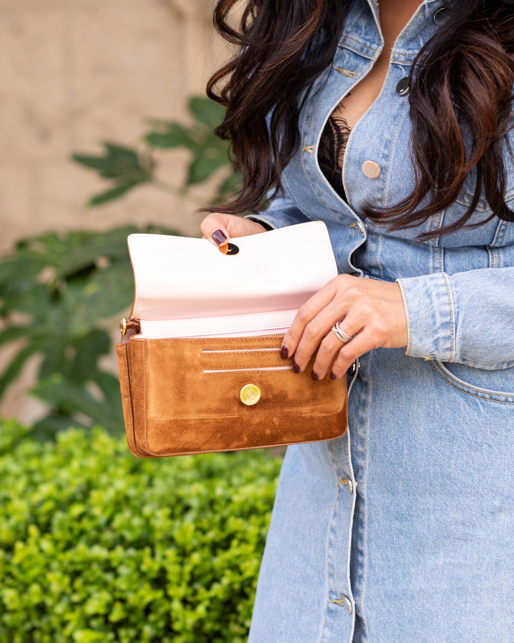 Model holding Aurora Bag Camel open front view showing exterior wallet and pink interior.